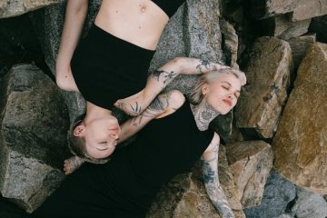 Two women showcasing the hottest tattoo trends, each adorned with unique inked designs that reflect their individual style and personality.