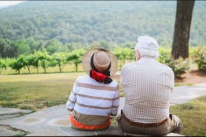 Senior couple sitting together, smiling and thriving in their retirement.