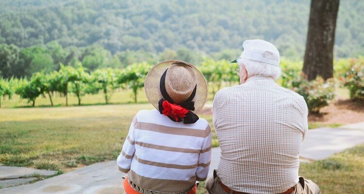 Senior couple sitting together, smiling and thriving in their retirement.