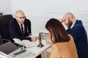 A couple sitting with a divorce lawyer, discussing the wife's entitlements in a divorce.