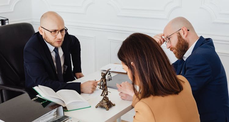 A couple sitting with a divorce lawyer, discussing the wife's entitlements in a divorce.