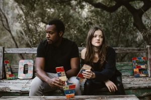 A couple sits solemnly beside a broken love showpiece, symbolizing the emotional pain of legal separation.