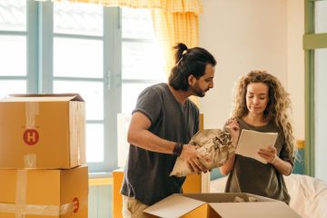 A couple reviewing a moving home checklist, ensuring all tasks are completed for a smooth transition.